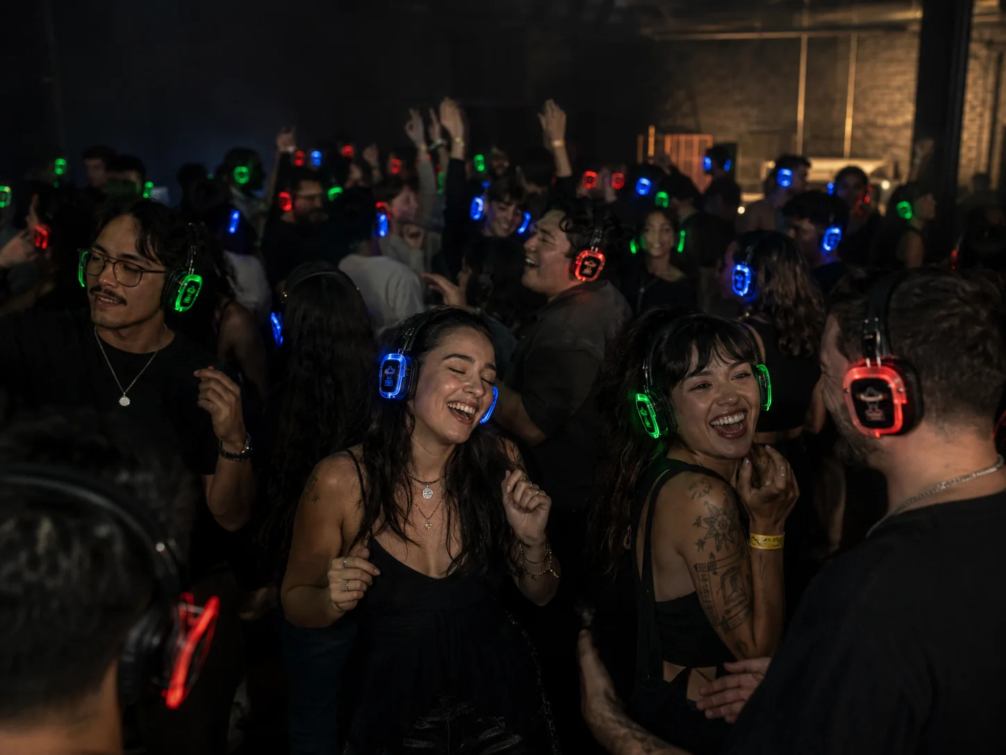 Volle dansvloer met oplichtende silent disco koptelefoons